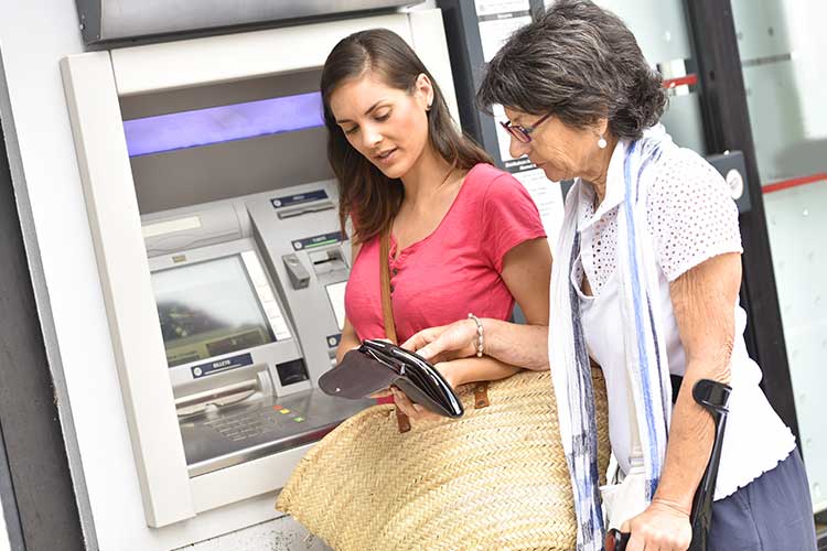 carer taking participant's money out at atm