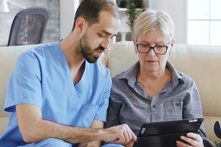 carer showing information to participant on tablet