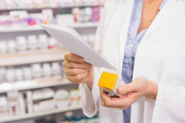 worker reading medication and prescription