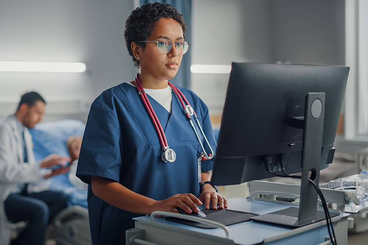 female health professional working on computer at a standing desk